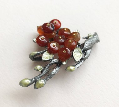 Kırmızı ve yeşil üzümlü metal bir saç tokasının yakın çekimi