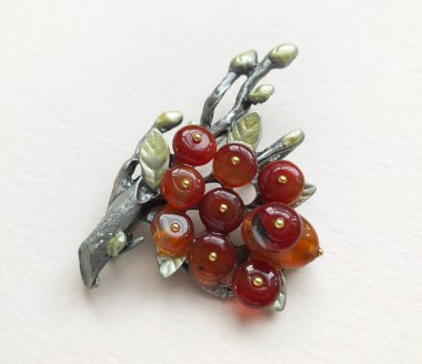Beyaz arkaplanda kırmızı ve yeşil meyvelerden yapılmış broş.