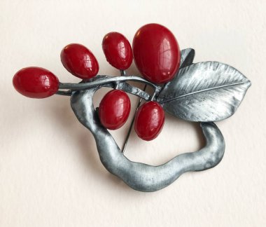 Beyaz arka planda kırmızı böğürtlenli klasik metal broş.