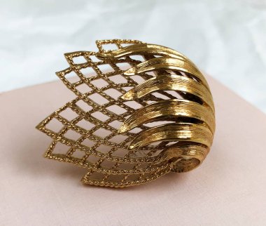 Beyaz arka planda altın antika broş, yakın plan.