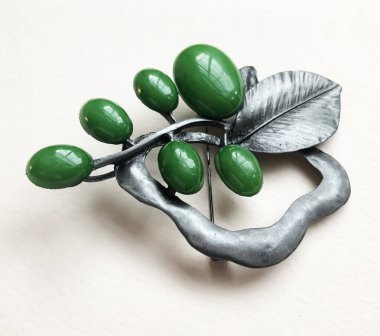 Beyaz arka planda doğal yeşil değerli taşlardan yapılmış mücevherler.