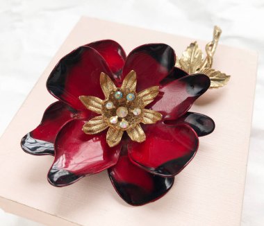 Beyaz arka planda altın madalyalı kırmızı çiçek. Üst görünüm.