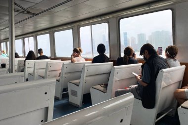 New York City, New York, New York, New York, ABD 'deki bir feribotun camından dışarı bakan bir grup insanın görüntüsü.