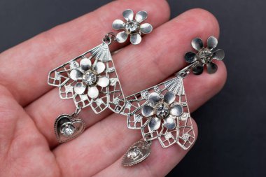 Elinde sahte elmaslar olan gümüş küpeler.