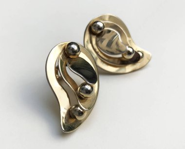 Beyaz arka planda bir çift altın küpe. Yakın plan..