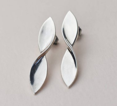 Beyaz arka planda gümüş küpeler. Mücevherler, aksesuarlar.