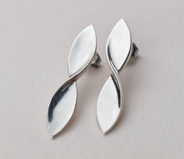 Beyaz arka planda gümüş küpeler. Mücevher ve aksesuarlar..