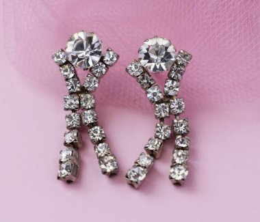 Pembe arka planda elmas küpeler yakın plan makro fotoğraf