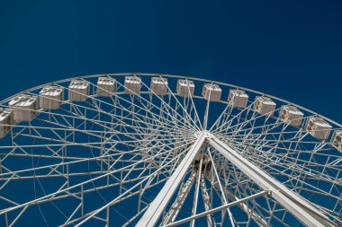 Mavi gökyüzünün arka planında dönme dolap, yakın plan.