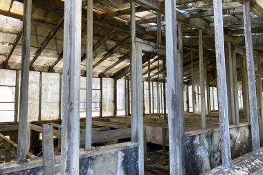 Bir sürü penceresi ve yıkık bir hangarı olan terk edilmiş eski bir bina.