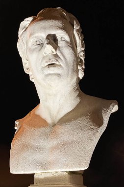 Fenerlerin ışığında bir adamın heykeli