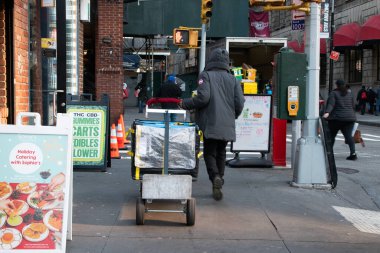 Manhattan, NYC, New York, ABD, Teslimat konsepti, teslimatçı ya da kurye New York sokaklarında kutular ile el arabası sürüyor