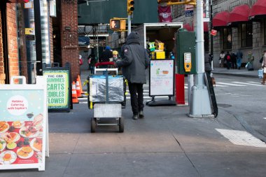 Manhattan, NYC, New York, ABD, Teslimat konsepti, teslimatçı ya da kurye New York sokaklarında kutular ile el arabası sürüyor
