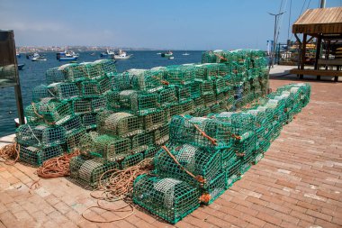 Bir yığın ıstakoz kapanı ve plastik kutu. Portekiz 'in Cascais limanında balık ağları