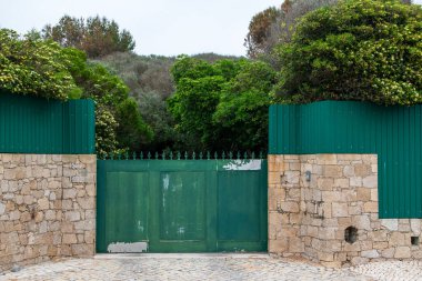 Portekiz, Cascais 'in merkezindeki bir caddede yeşil metal kapı.