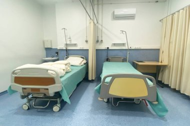 İçinde boş yataklar ve tıbbi malzemeler olan bir hastane odası..