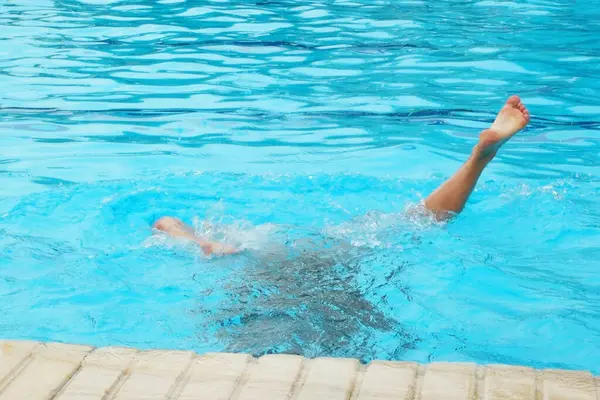 Güneşli bir günde havuzda yüzen kız, yakın plan.