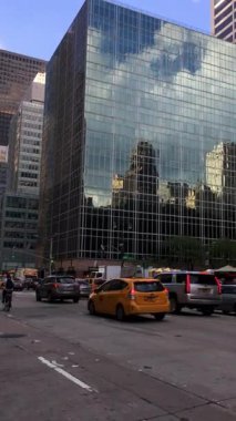 İnsanlar ve otomobiller New York City caddelerini doldurarak Manhattan, New York, ABD 'nin gösterişli şehir manzarasını resmediyor..