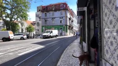 Lizbon 'daki turistler ünlü sitelerin yakınlarındaki tarihi caddelerde yürüyorlar.