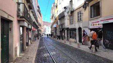 Lizbon 'un güzelliğini keşfeden turistler işlek caddelerinde ve manzaralarında.