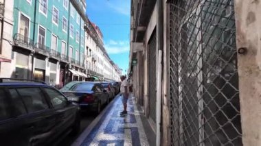 Turistler kentin canlı sokaklarında yürürken Lizbon 'un simgelerinin keyfini çıkarıyorlar.