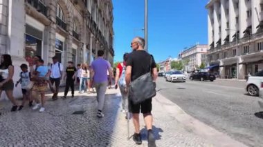 Tarihi yerleri almak için Lisbons sokaklarında yürüyen kalabalıklar.