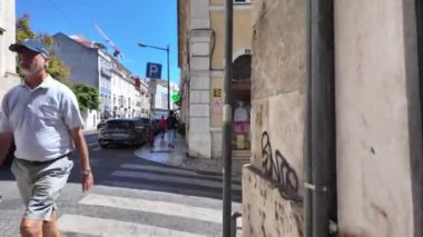 Lizbon 'un hareketli caddelerini ve ünlü simgelerini gezen turistler.