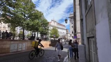 Lizbon 'un canlı sokaklarını ikonik manzaralarla gezen ziyaretçiler.