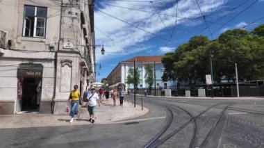 Turistler Lisbons caddelerinde ve şehir simgelerinde yürüyüş yapıyorlar..