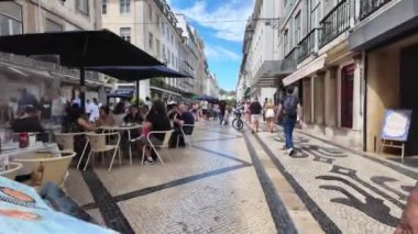 Lizbon sokaklarında dolaşıp ünlü yerlere giden turistler.