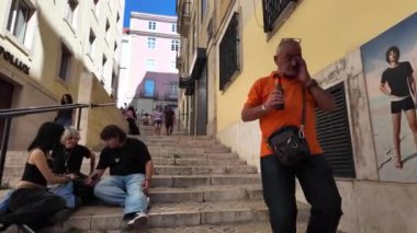 Lizbon 'un canlı caddelerinde ziyaretçiler manzaranın keyfini çıkarıyorlar..