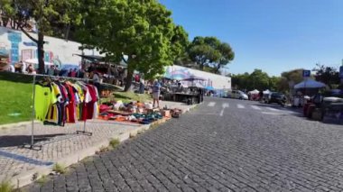 Tarihi bir bölgedeki Lisbons ikonik bit pazarının atmosferini emen turistler.