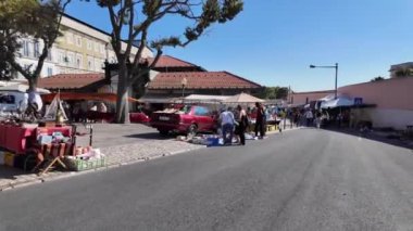 Lisbons tarihi bit pazarının tadını çıkaran ziyaretçiler, eski ve güzel kasabasında.