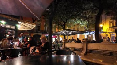 Lizbon 'un tarihi sokakları gece lambaları altında, gezginler onu ıslatıyor..