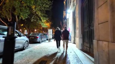 Lizbon 'da gece vakti, insanlar tarihi yollar ve işaretler boyunca yürüyorlar..