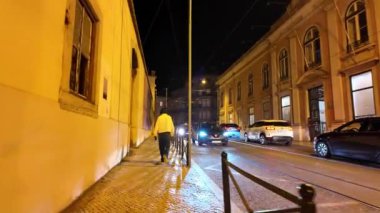 Geceleri parlayan Lizbon simgeleri, ikonik rotaları keşfeden turistler.