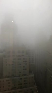New York 'un uzun gökdelenleri yağmur ve sisle örtülmüş, dikey panoramik bir videoda çekildi..