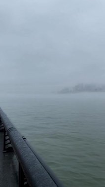 Yağmurla ıslanmış New York gökdelenleri dikey bir videoda siste kayboluyor..