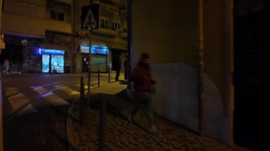 İkonik Lizbon tramvayı 28, gece şehir manzarasını gösteriyor..