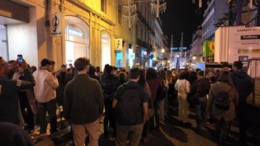 İnsanlar ışıkların parlamasını beklerken Lisbons caddeleri tatil neşesiyle dolup taşıyor. Lizbon, Portekiz