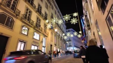 Alacakaranlıkta Lizbon 'da yürürken, yılbaşı ışıkları simgelerde parıldarken.