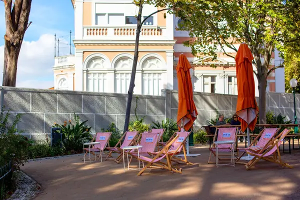 Bir otelin terasında plaj sandalyeleri ve şemsiyeler..