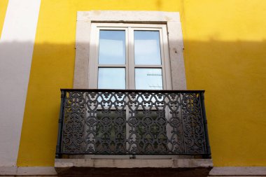 Lizbon, Portekiz 'de sarı bir duvarda balkon.