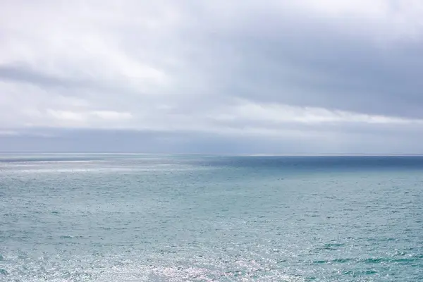 Arka planda bulutlu gökyüzü ve mavi deniz manzaralı deniz manzarası. Huzurlu Deniz Burnu
