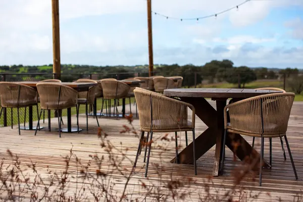 Kırsaldaki bir restoranın terasında masa ve sandalyeler.