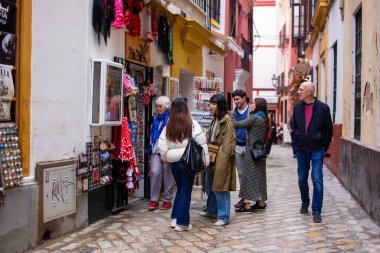 Sevilla sokaklarında yürüyen turistler.