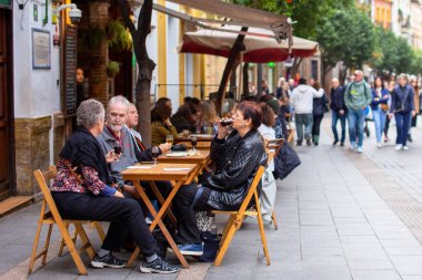 İspanya, Seville 'deki açık kafede oturan kimliği belirsiz insanlar.