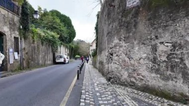 Gezginler aşağıda yürürken, sis Sintra çatıları üzerinde yuvarlanıyor.