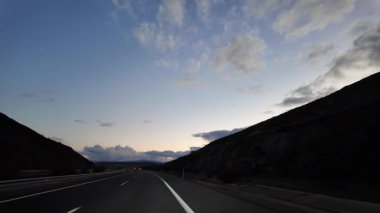 Önümüzde bir aracın içinden görünen açık yol var.