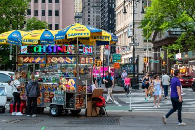 Meşgul bir sokak köşesinde klasik bir New York sosisli arabası. Manhattan, New York 'ta sokak yemekleri büfesi.